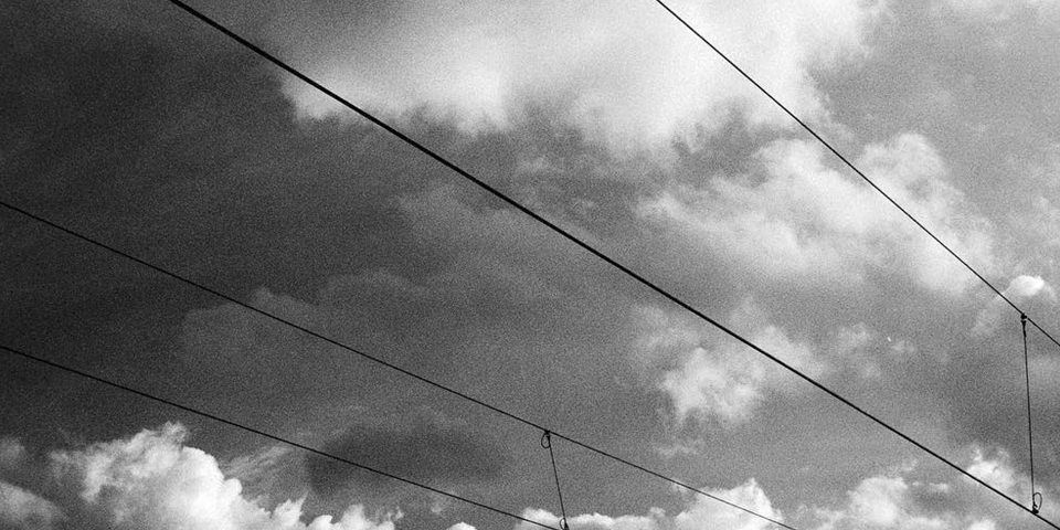 Stromleitungen vor wolkigem Himmel.