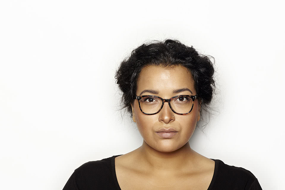 Portrait einer Frau mit dunklen Haaren und Brille.