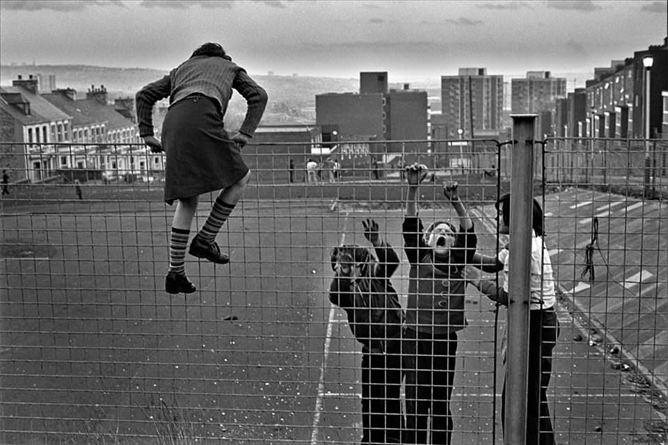 Kinder klettern über einen Zaun