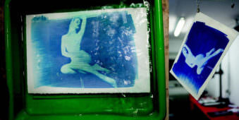 Bild einer Frau im Akt in blau in einer Entwicklerwanne und an einer Trockenleine.