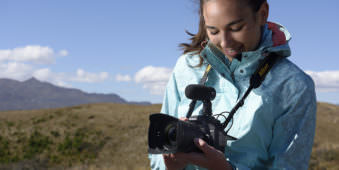 Frau mit Kamera in Landschaft