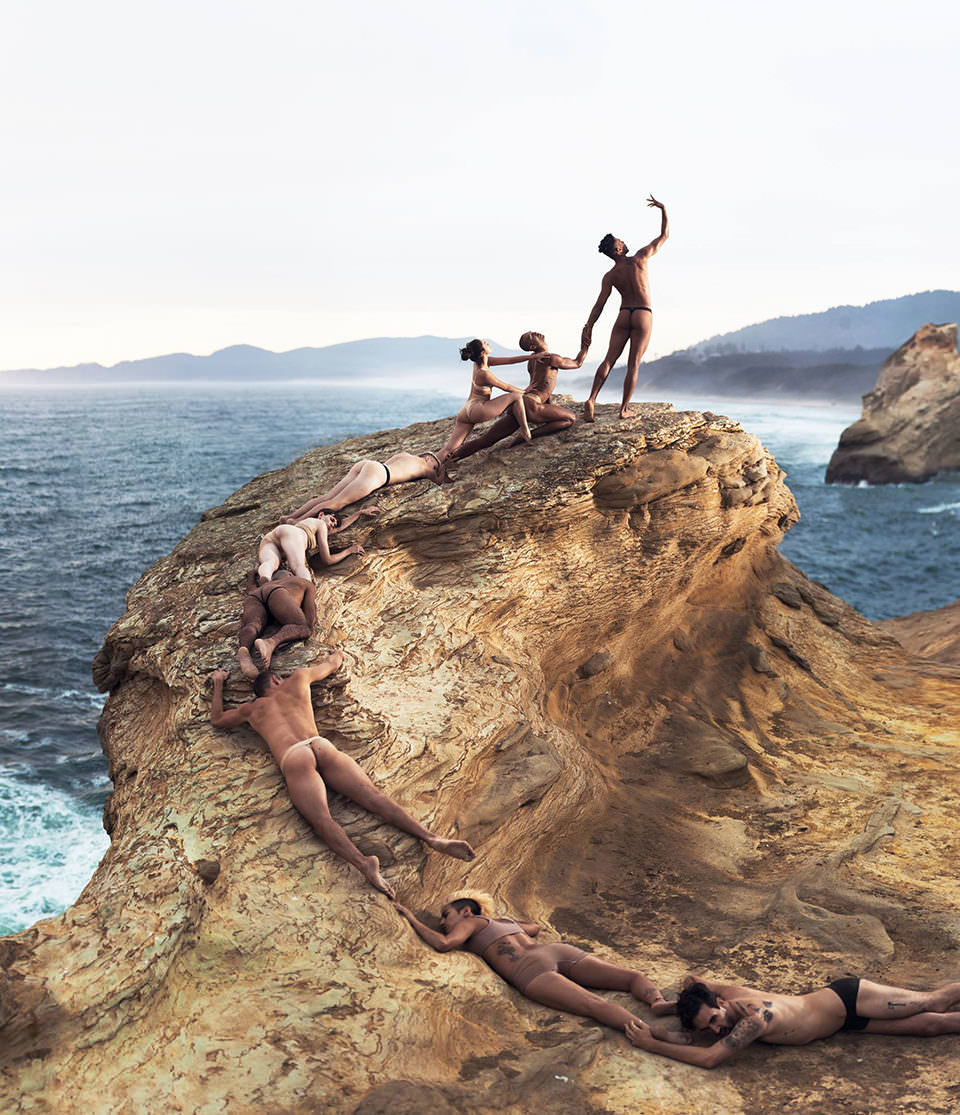 Nackte Menschen formen ein Kunstwerk am Strand
