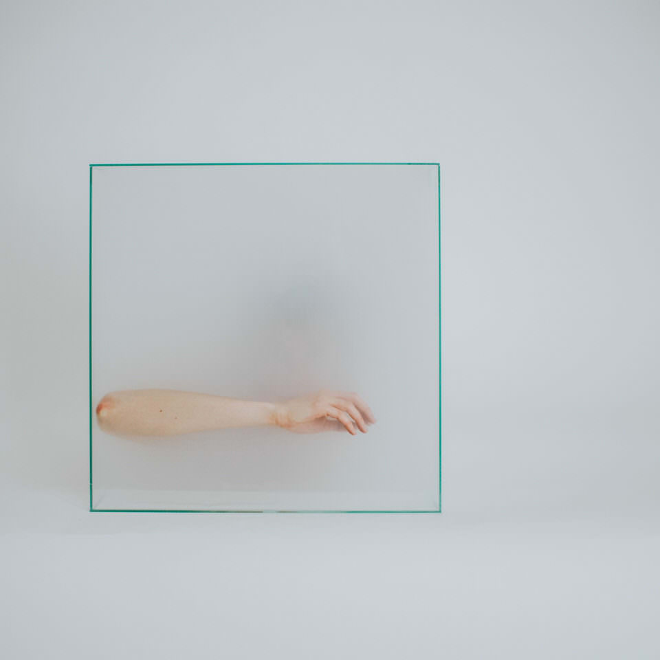 Arm in einer Glasbox