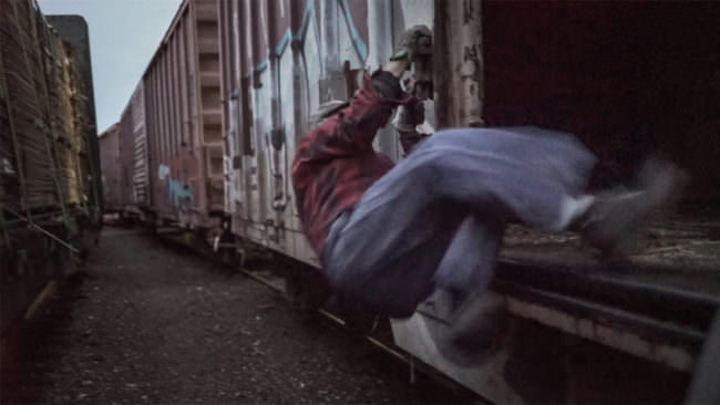 Eine Person springt in einen Güterzug