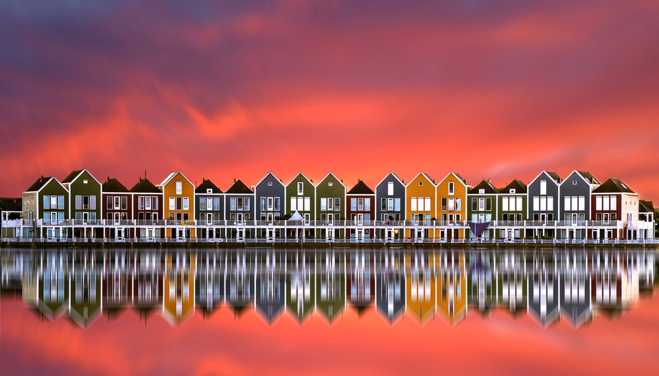 Bunte Häuser spiegeln sich im Wasser im Sonnenuntergang