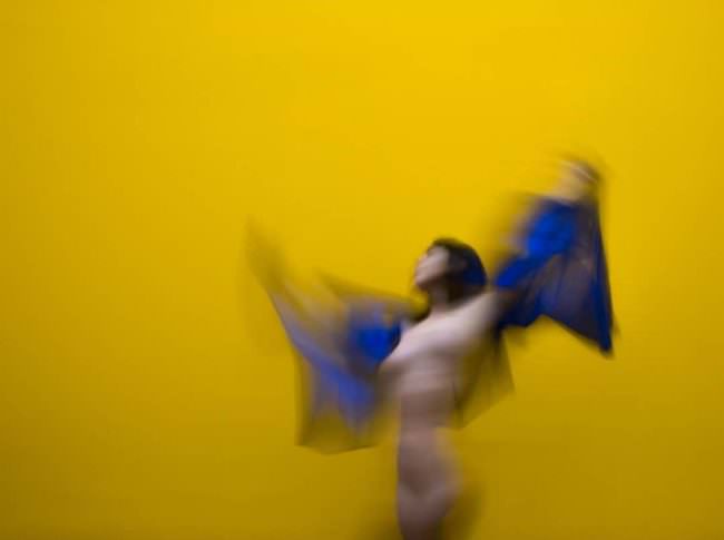 in Bewegung verwischtes Frauenportrait vor gelb