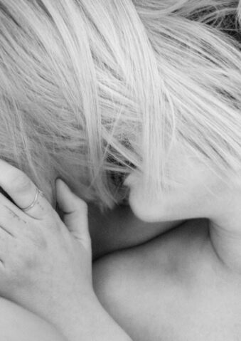 Zwei Menschen küssen sich, Harre liegen über den Gesichtern