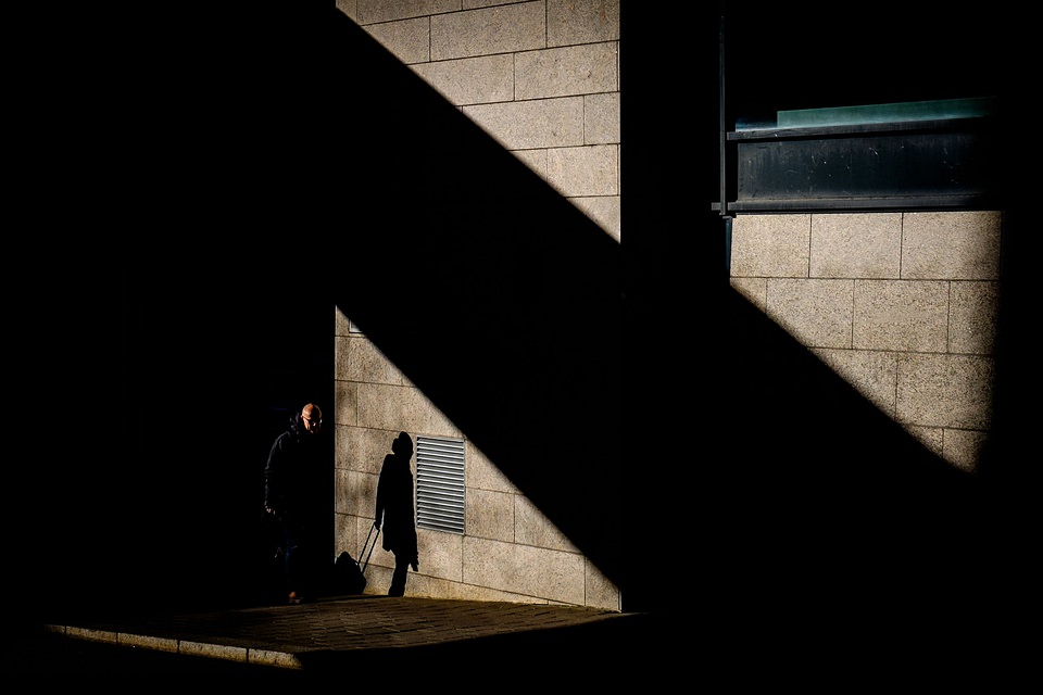 Mensch und Schatten auf einer Hausfassade