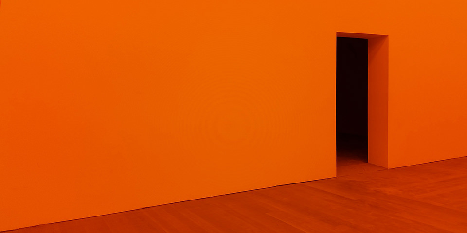Oranger Raum mit dunklem Eingang