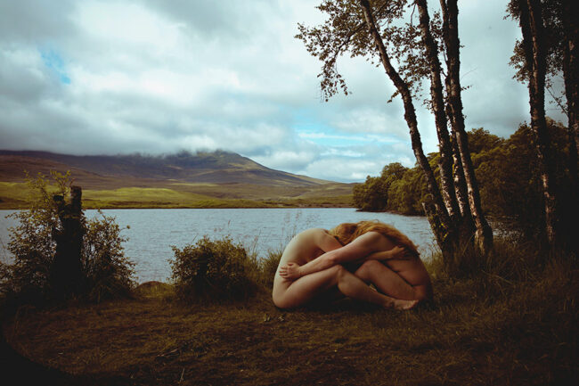 zwei nackte Menschen umarmen sich in einer Landschaft