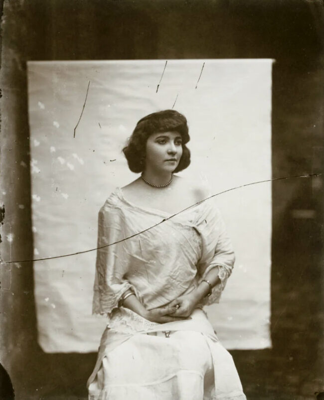 Eine Frau posiert vor einem weißen Tuch