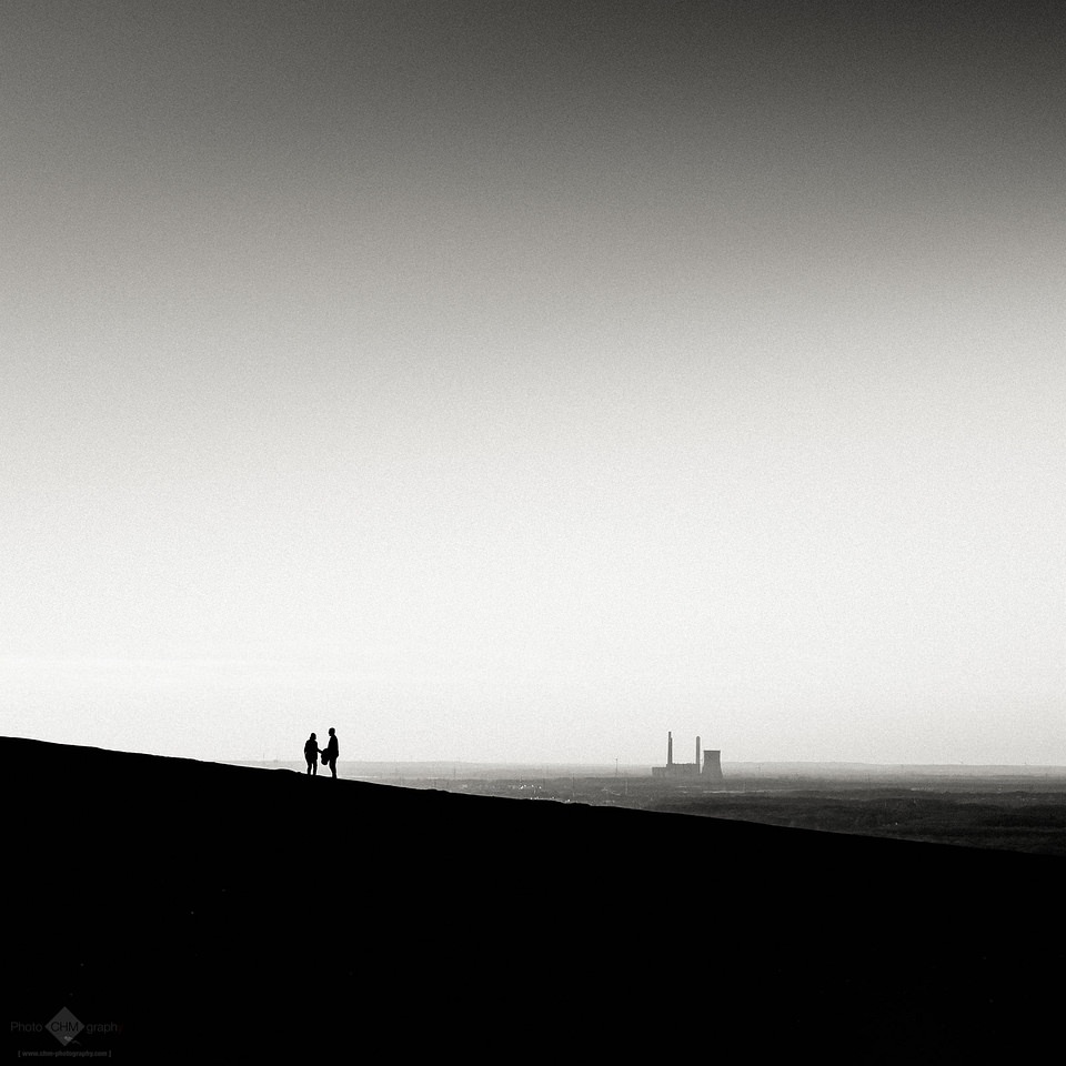 zwei Menschen auf einem Hügel vor Stadt in der Ferne