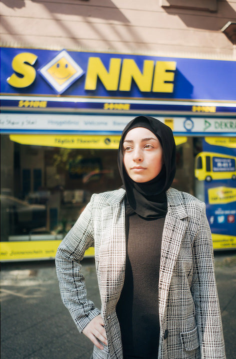 Frau vor einem Laden mit der Aufschrift "Sonne"
