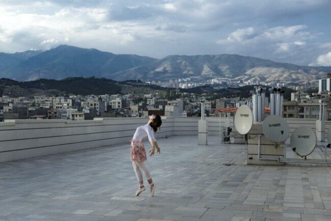 Frau tanzt auf dem Dach eines Hauses