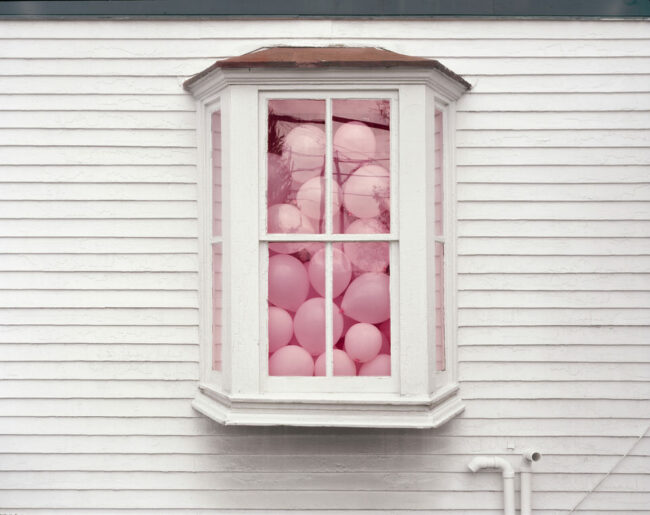 Ein Fenster voller rosa Luftballons