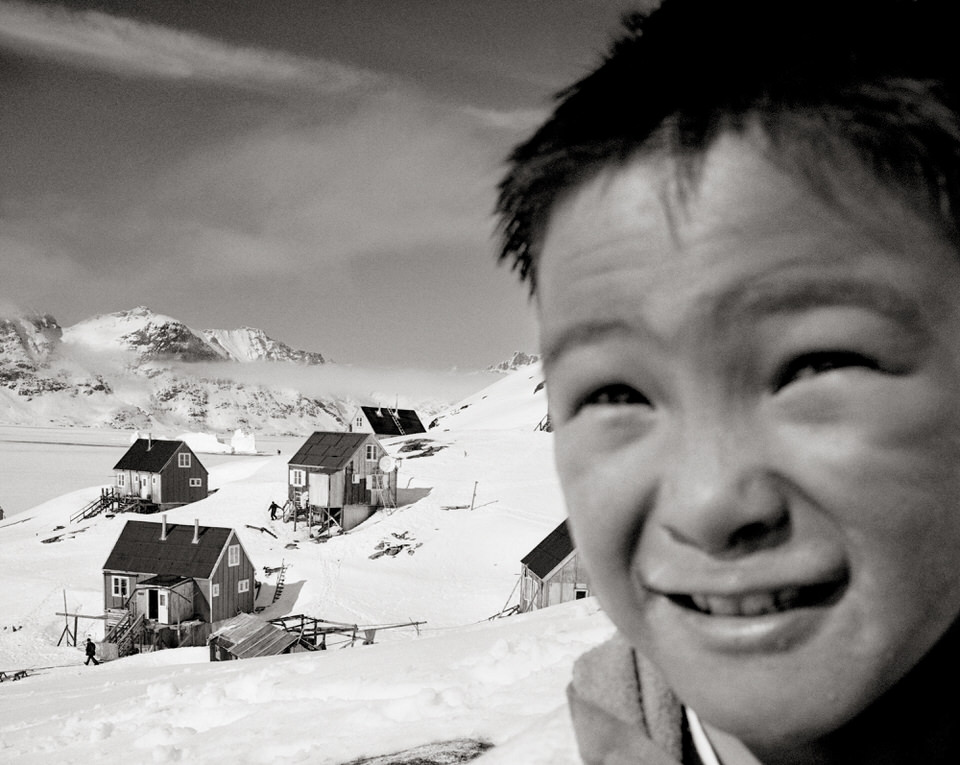 Kind vor Häusern im Schnee