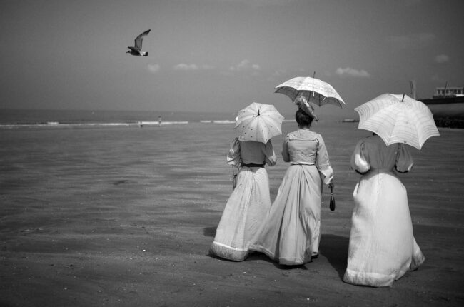Frauen mit Sonnenschirm am Strand