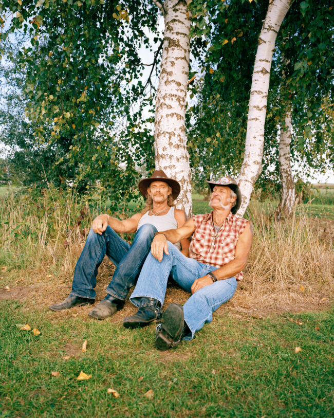 Zwei Männer lehnen an Birken