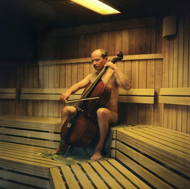 nackter Mann spielt in einer Sauna Kontrabass