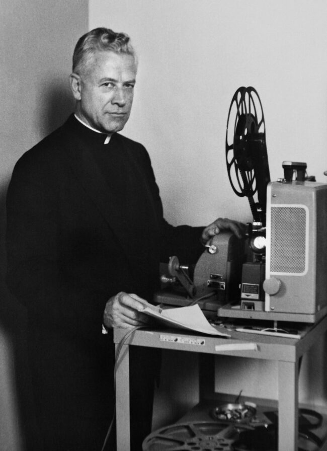 Priester mit Projektor