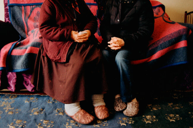 Zwei Menschen sitzen auf einem Bett, Detailansicht