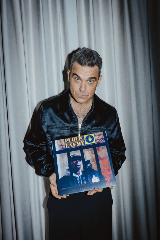 Robbie Williams mit Schallplatte in der Hand