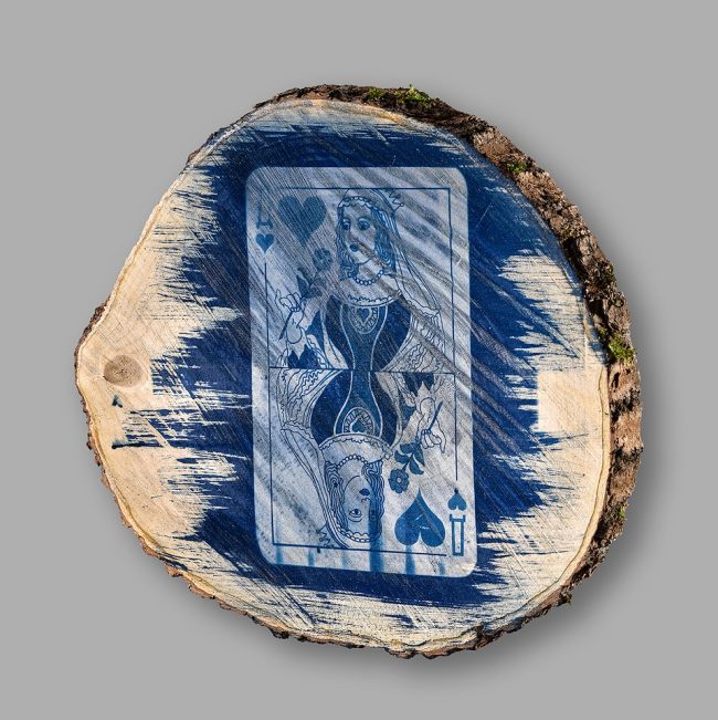 Cyanotypie einer Spielkarte auf einer Baumscheibe