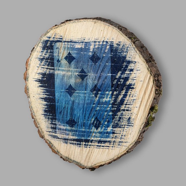 Cyanotypie einer Spielkarte auf einer Baumscheibe