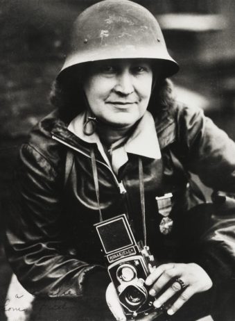 Portrait: Frau mit Stahlhelm und Kamera