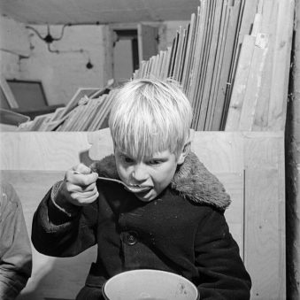 Ein Junge löffelt Suppe.