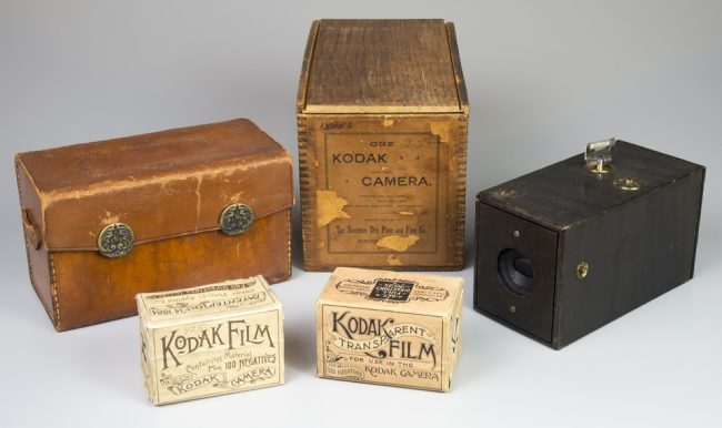 Kamera mit Kiste, Tasche und Filmen.